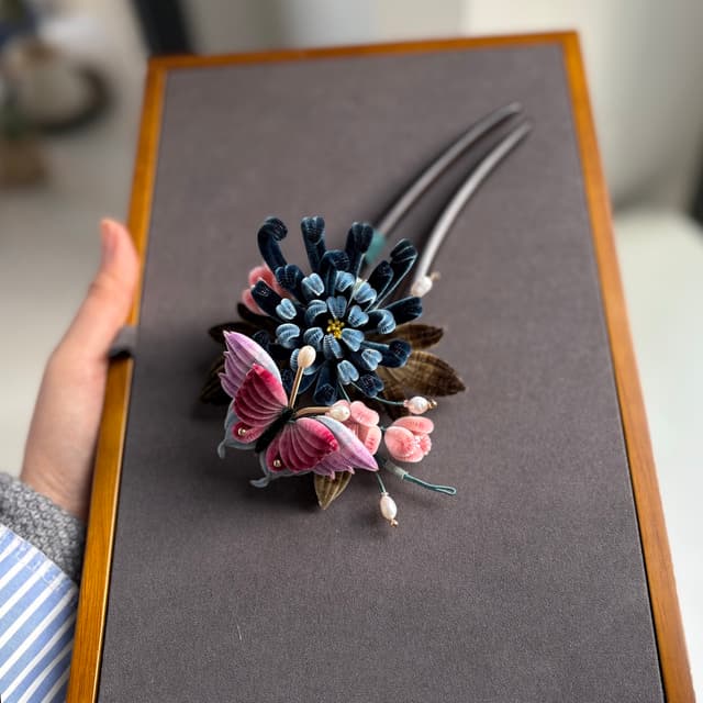 Ink Dance — Chrysanthemum & Butterfly Hairpin — the piece resting in soft light
