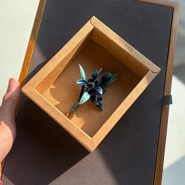 Orchid Heart — Blue-and-White Porcelain Brooch — the piece resting in soft light