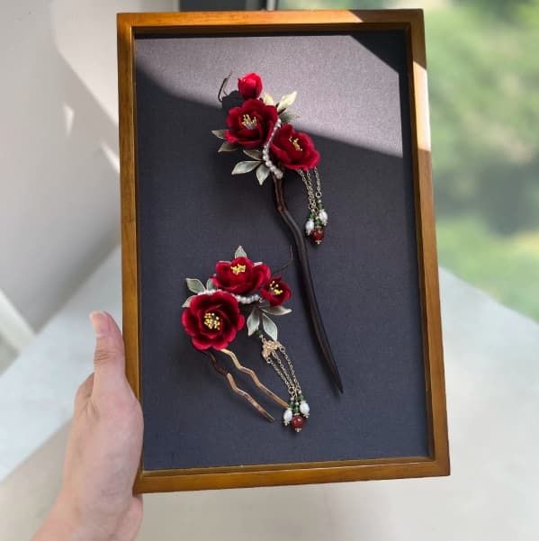 Crimson velvet peony hairpin and comb duo presented in a framed case